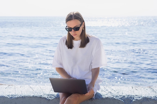 Felicidad de trabajar en el mar Una mujer joven con una computadora portátil en el fondo del mar Clima soleado de verano