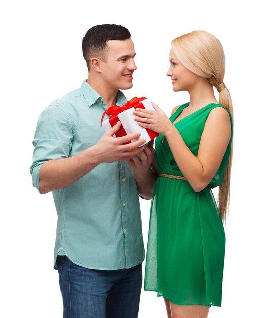 felicidad, vacaciones, celebración y concepto de pareja - pareja sonriente con caja de regalo