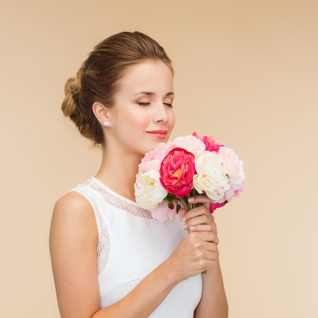 felicidade, casamento, feriados e conceito de celebração - sorrindo noiva ou dama de honra em vestido branco com buquê de flores