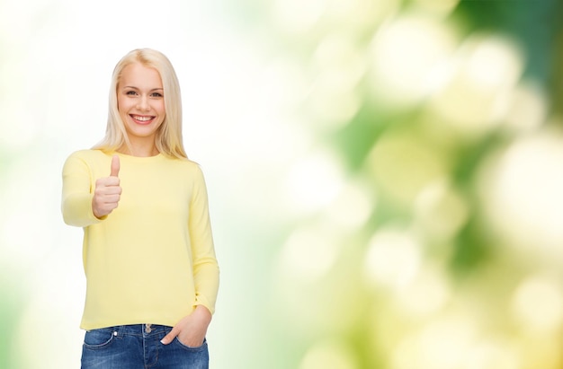 felicidade, gesto e conceito de pessoas - jovem sorridente em roupas casuais mostrando polegares para cima