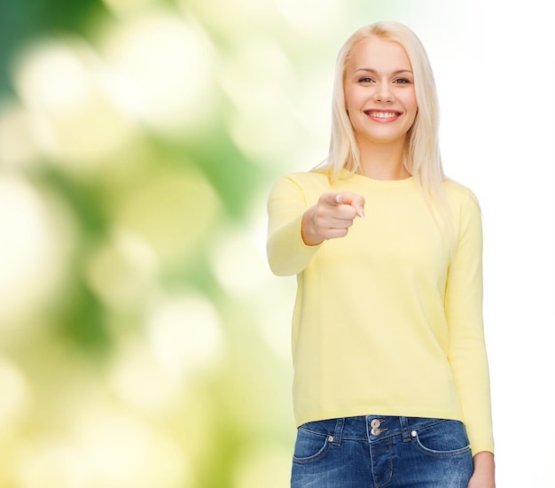 Felicidade, gesto e conceito de pessoas - mulher sorridente apontando o dedo para você