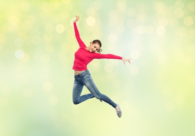 felicidade, liberdade, movimento e conceito de pessoas - jovem feliz pulando ou dançando no ar sobre fundo de luzes verdes de verão