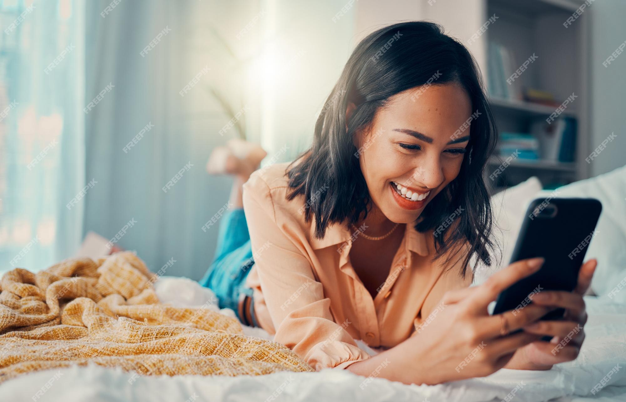 Jovem mulher sorrindo e rindo enquanto enviava mensagens de texto em um  telefone em casa mulher alegre conversando com seus amigos nas mídias  sociais navegando online e assistindo memes engraçados da internet