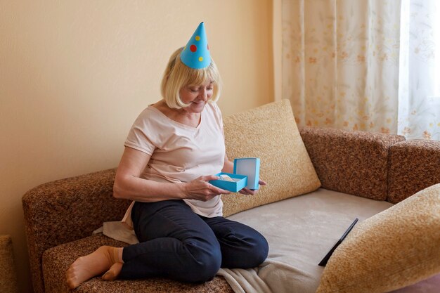 Feliz abuela celebrando el cumpleaños junto con su familia a través de internet en cuarentena