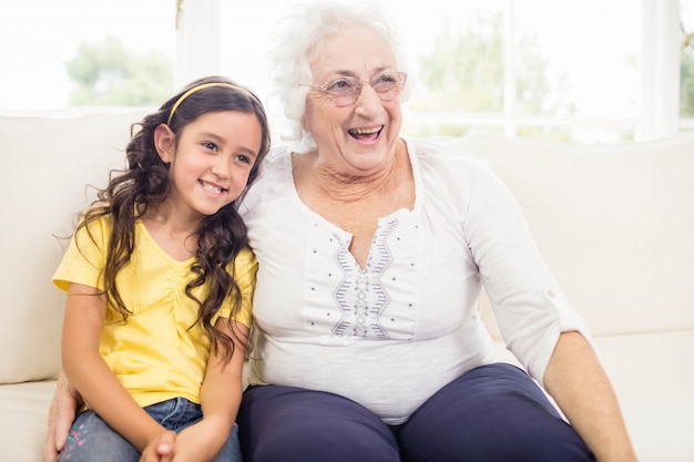 Feliz abuela y nieta sonriendo en casa