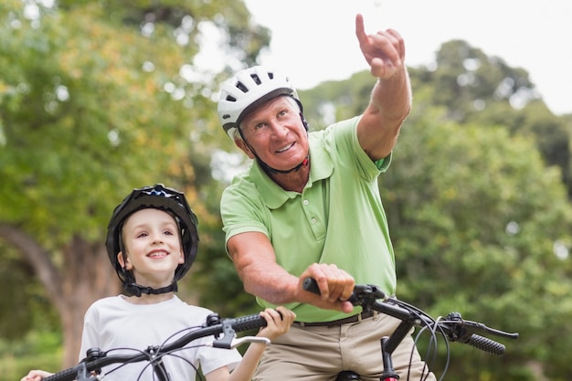 Feliz abuelo con su nieta en su bicicleta