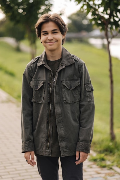 Feliz adolescente caminando al aire libre en el parque en otoño chico en chaqueta de color caqui