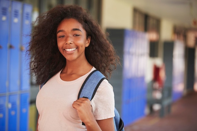 Foto feliz adolescente negra sorrindo no corredor do ensino médio