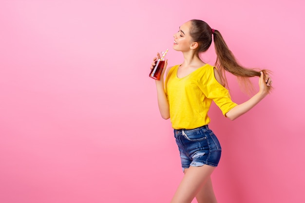 Feliz adolescente de pie con una botella de bebida