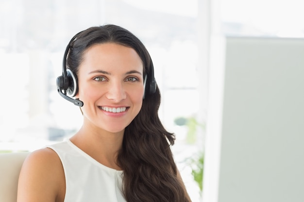 Feliz agente de call center sentado en su escritorio