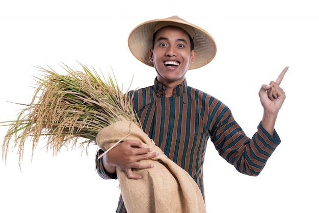 Feliz agricultor asiático con granos de arroz