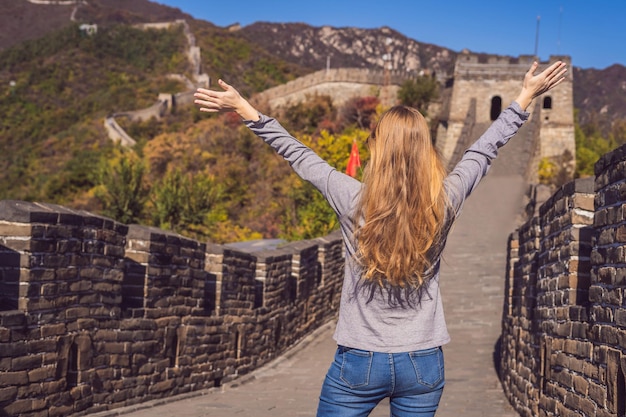 Feliz alegre alegre mujer turista en la gran muralla china divirtiéndose en viajes sonriendo riendo y