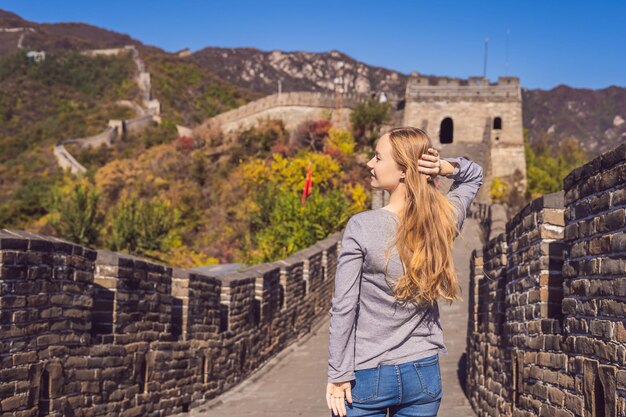 Feliz alegre alegre mujer turista en la gran muralla china divirtiéndose en viajes sonriendo riendo y