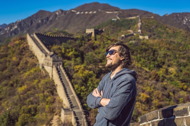 Feliz alegre alegre turista en la Gran Muralla China divirtiéndose en viajes sonriendo riendo y bailando durante un viaje de vacaciones en Asia Hombre visitando y haciendo turismo destino chino