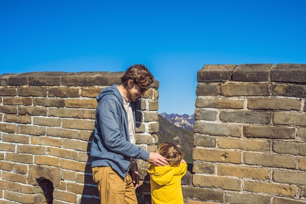 Feliz alegre alegre turistas padre e hijo en la gran muralla china divirtiéndose en viajes sonriendo