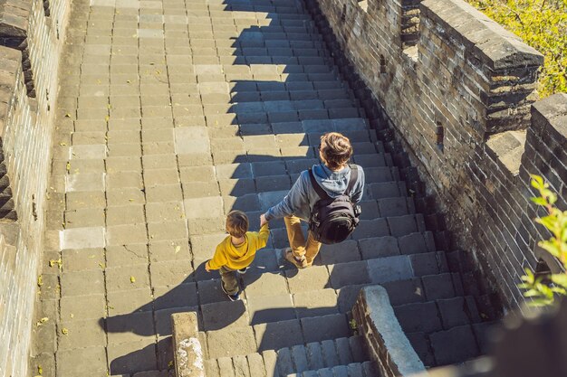 Feliz alegre alegre turistas padre e hijo en la gran muralla china divirtiéndose en viajes sonriendo