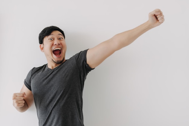 Feliz y alegre cara divertida hombre asiático en camiseta negra aislado en blanco