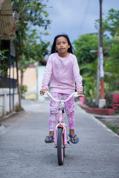 Feliz alegre criança asiática andando de bicicleta