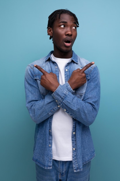 Feliz alegre hombre africano con cabello rizado en un look casual experimenta emociones agradables