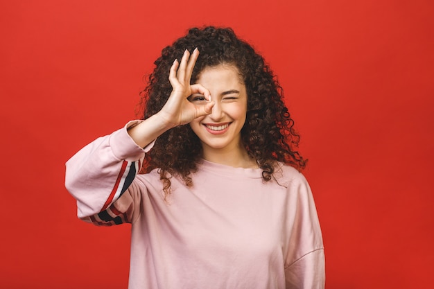 Feliz alegre joven con cabello rizado regocijándose con noticias positivas