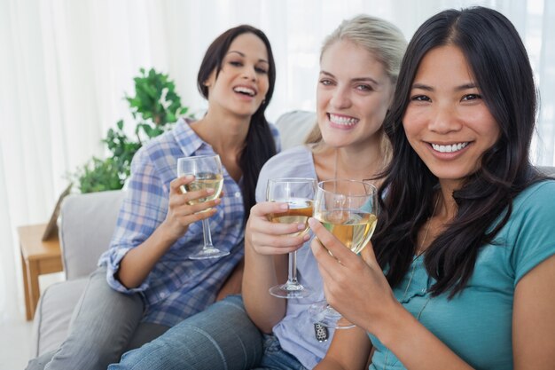 Feliz amigos com vinho branco juntos olhando câmera