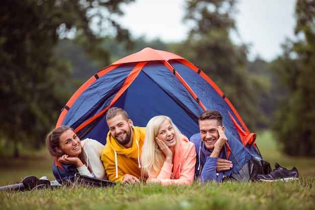 Feliz amigos deitados na sua tenda