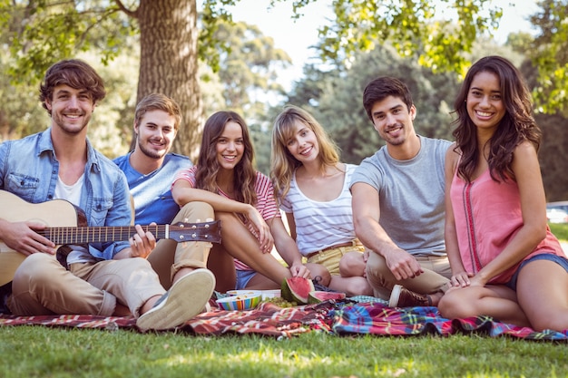 Feliz amigos em um parque com um piquenique