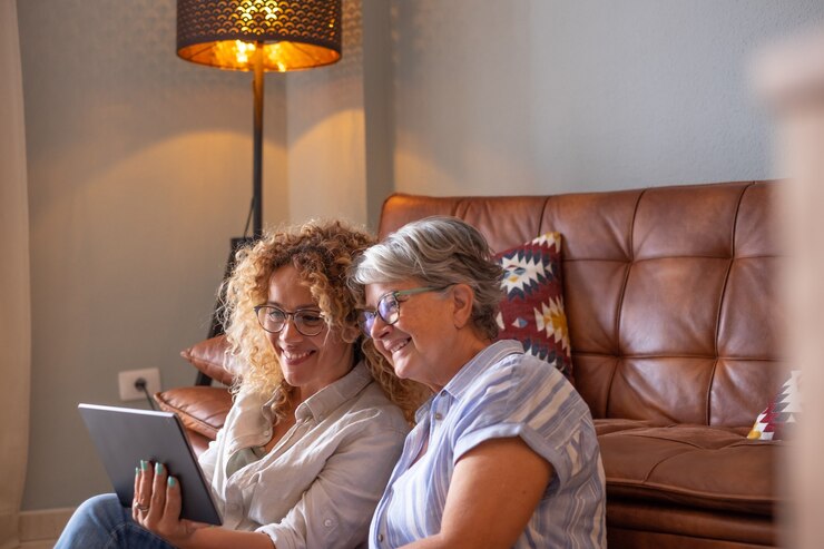 Feliz amorosa madre madura mayor e hija riendo cuidando sonriendo feliz madre de mediana edad senior divirtiéndose en casa pasando tiempo junto con dispositivo tecnológico