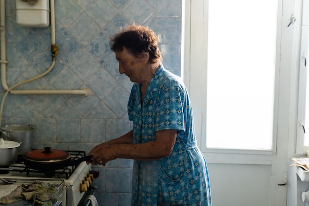 Feliz anciana cocinando en casa