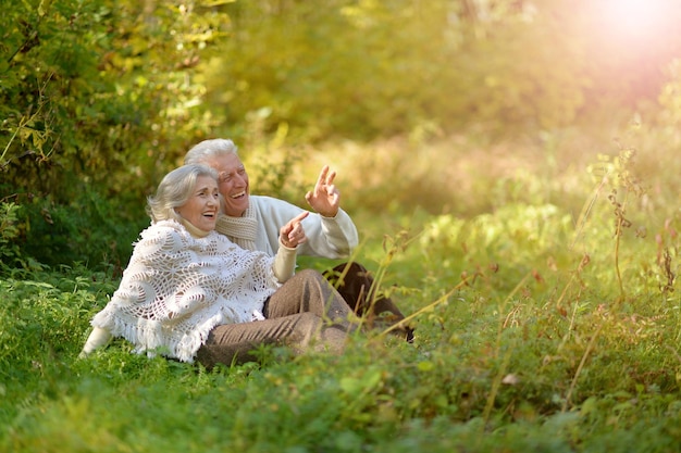 Feliz anciana y hombre en el parque mujer señalando con el dedo