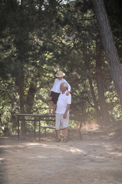 Feliz anciano abuelo con lindo niñito jugando en el bosque