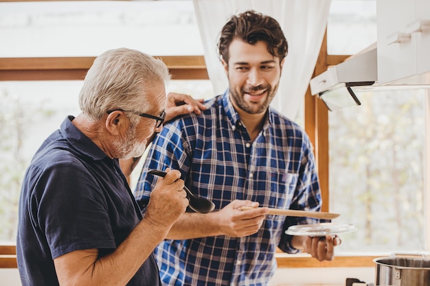 Feliz anciano disfruta cocinando con la familia en la cocina para la actividad de ocio en casa y el estilo de vida de las personas.