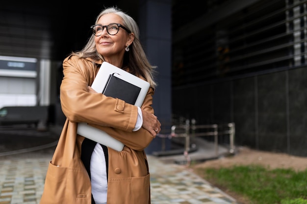 Feliz anciano hombre de negocios con una laptop en sus manos cerca del centro de negocios