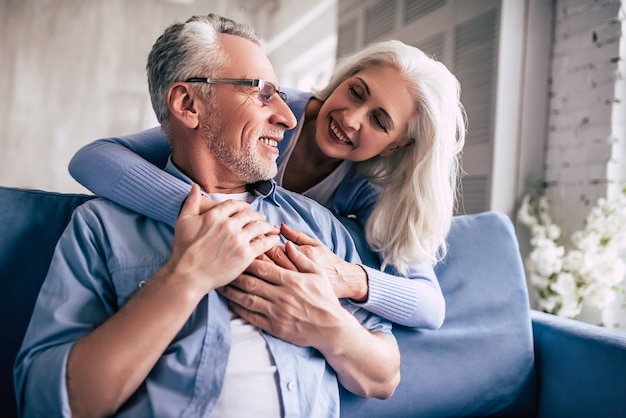 El feliz anciano y una mujer abrazándose.