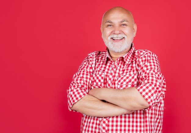 Feliz anciano o abuelo con camisa a cuadros de fondo rojo