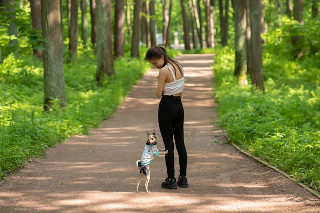 Feliz animal de estimação menina com um cachorro pequeno para passear