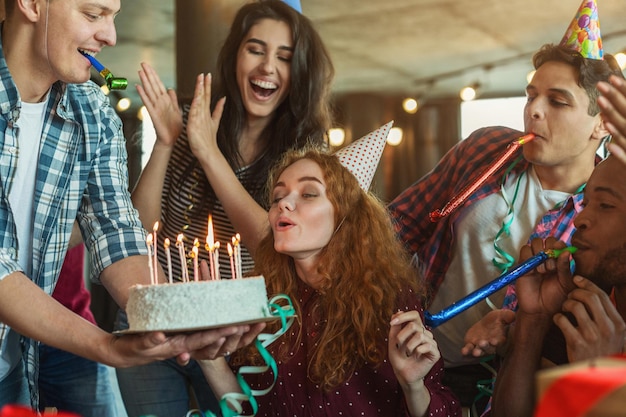 Feliz aniversariante soprando velas no bolo do feriado e fazendo um pedido, copie o espaço