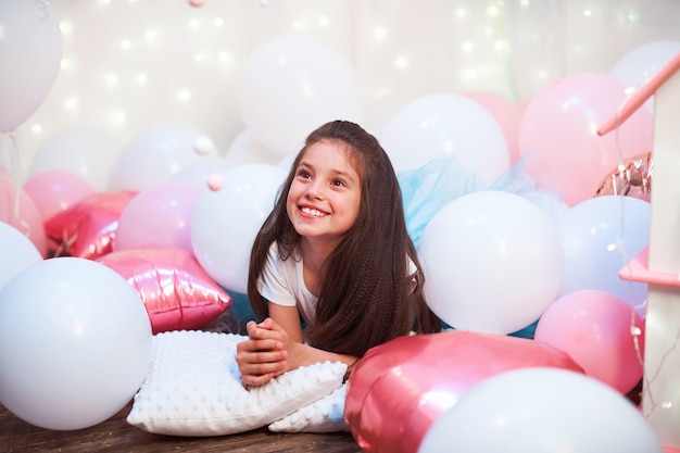 Feliz Aniversário! Retrato da menina bonitinha, brincando com casa de bonecas para bonecas.