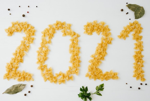 Feliz ano novo 2021 feito de macarrão e alguns ingredientes de cozinha.