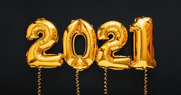 Feliz ano novo 2021 ouro texto balão de ar com fitas em preto.