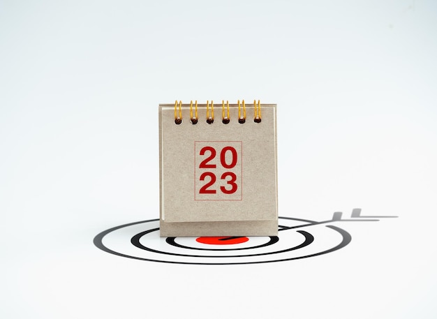 Feliz ano novo 2023 plano de fundo 2023 capa de calendário de mesa em pé no ícone de alvo grande isolado no fundo branco estilo mínimo Objetivos de negócios e conceitos de plano de ação de sucesso