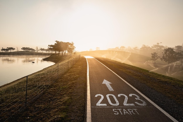 Feliz ano novo 20232023 simboliza o início do ano novo A carta começa o ano novo 2023 na estrada na estrada da rota da natureza perto do rio na manhã nascer do sol ecologia conceito de papel de parede verde