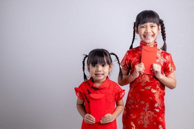 Feliz Ano Novo Chinês. garotinhas asiáticas sorridentes segurando um envelope vermelho