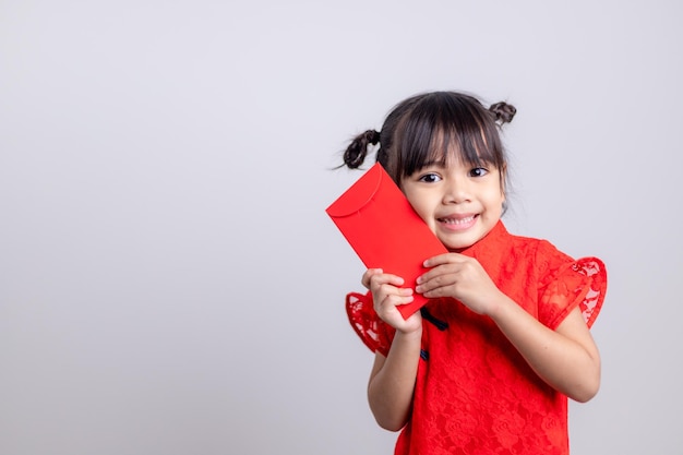 Feliz ano novo chinês. garotinhas asiáticas sorridentes segurando um envelope vermelho