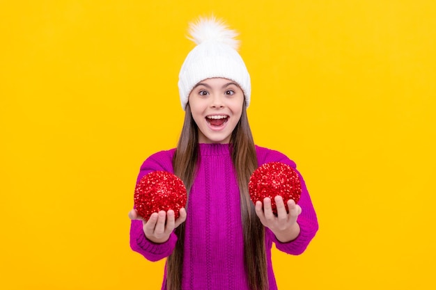 Feliz ano novo surpreendeu criança feliz no chapéu de inverno garoto com bolas de decoração