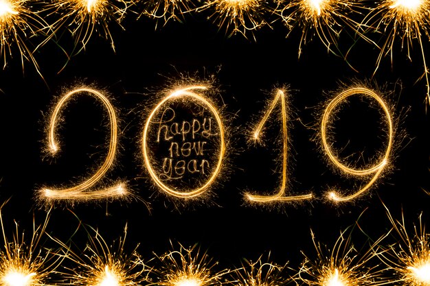 Feliz año nuevo 2018 texto escrito con fuegos artificiales Sparkle aislados sobre fondo negro