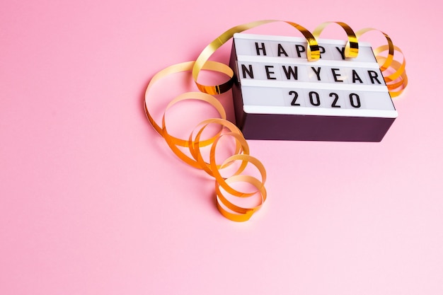 Feliz año nuevo 2020. La inscripción en una caja blanca con luz de fondo