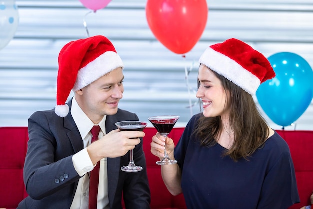 Feliz año nuevo 2022 concepto, pareja feliz sosteniendo copas de champaña tintineante en Navidad y fiesta de fin de año después de terminar el trabajo comercial