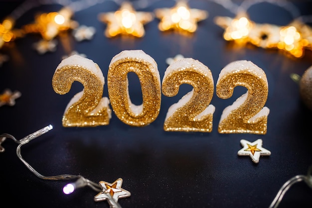 Feliz año nuevo 2022 fondo de vacaciones con adornos navideños dorados 2022 números con oro