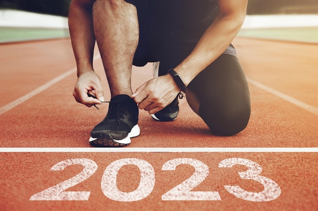 Feliz año nuevo 2023 2023 simboliza el comienzo del nuevo año Comience con un hombre preparándose para correr